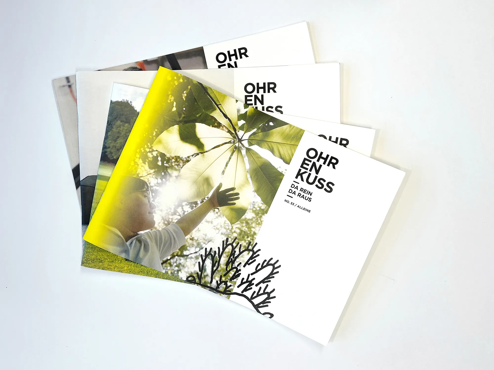 Foto von vier fächerartig präsentierten Exemplaren eines Magazins mit dem Titel„Ohrenkuss“